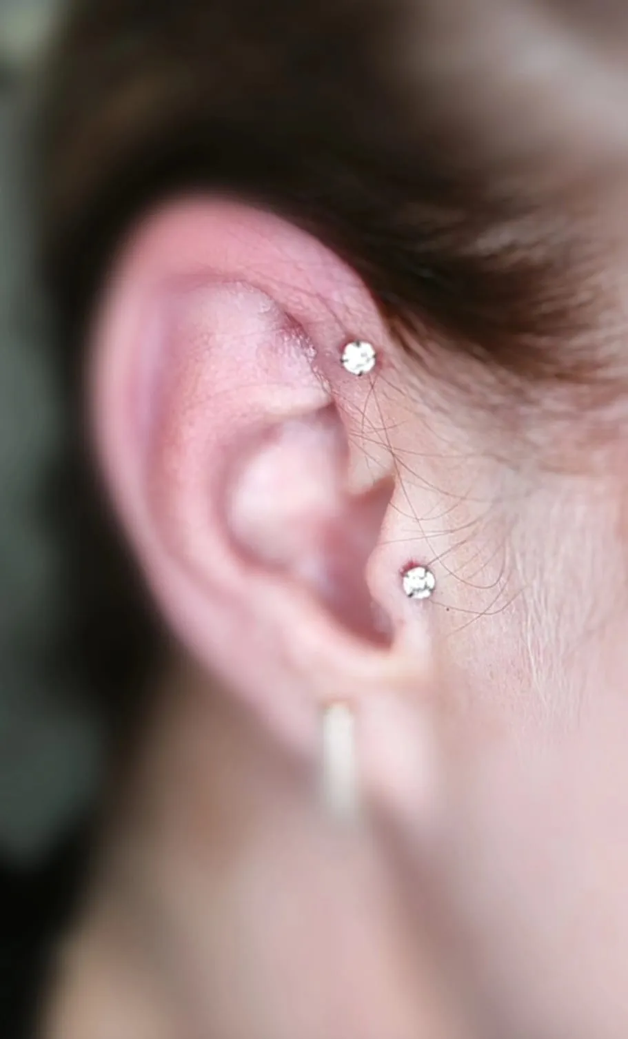 Piercing dva kamínky v uchu