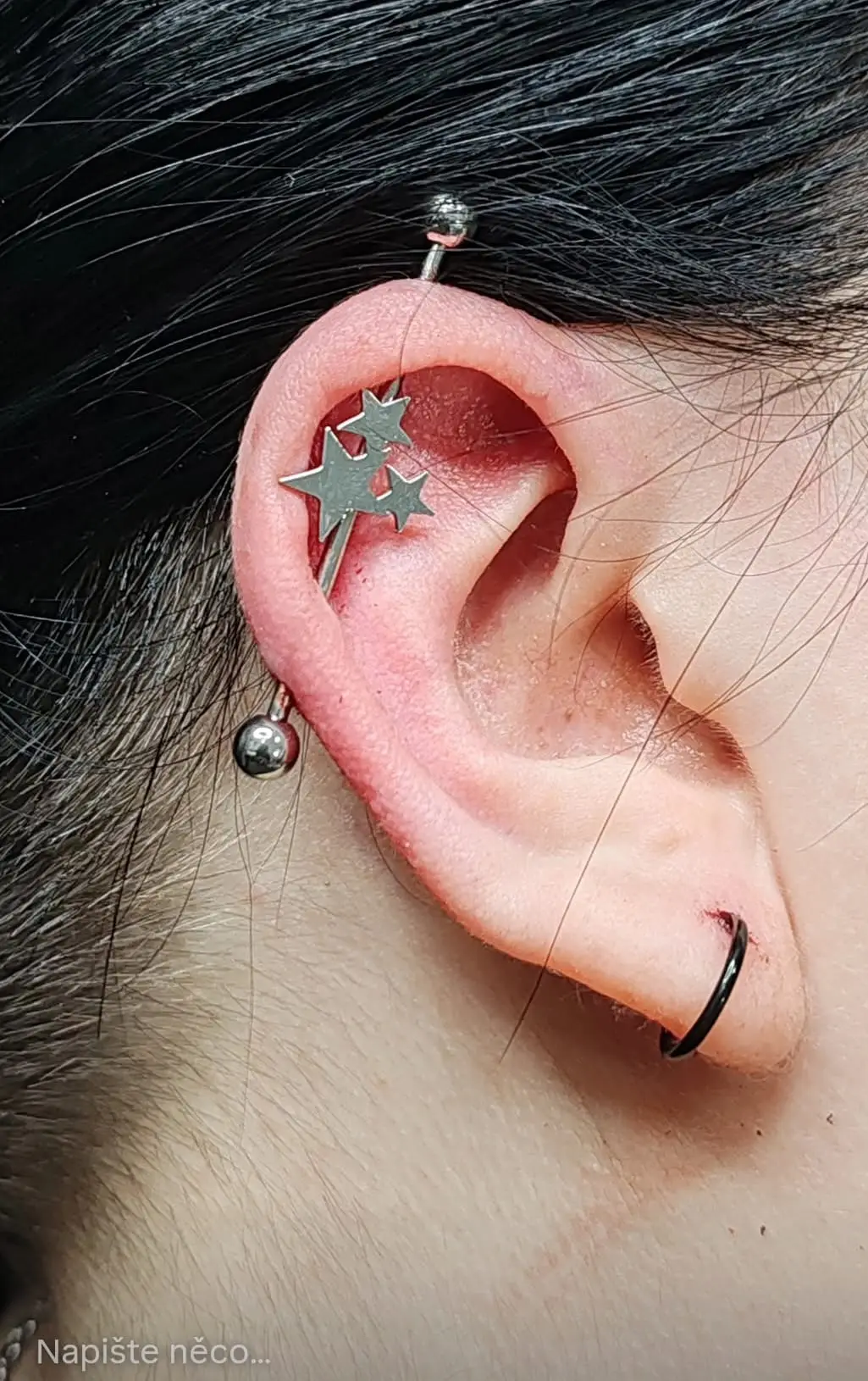Piercing v uchu s hvězdami